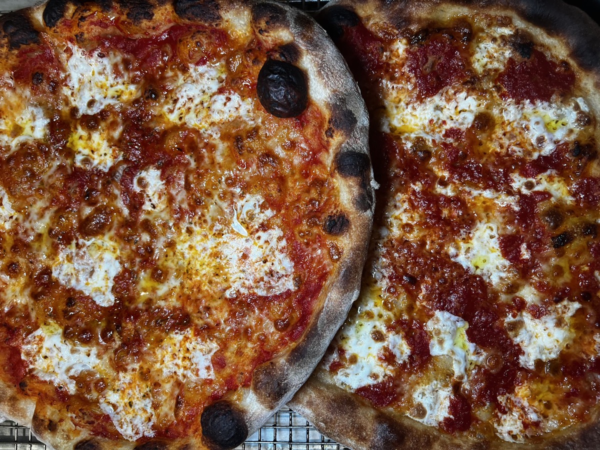 Two fresh wood-fired pizzas with bubbly crust by ChefLon