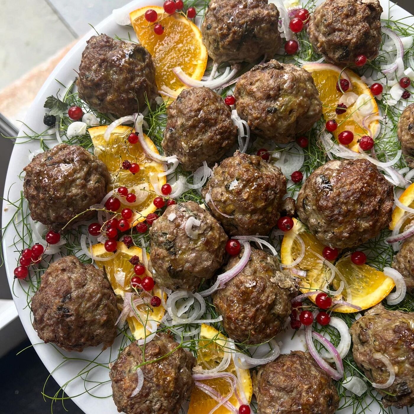 Beautifully plated meatballs with edible flowers — private event appetizer